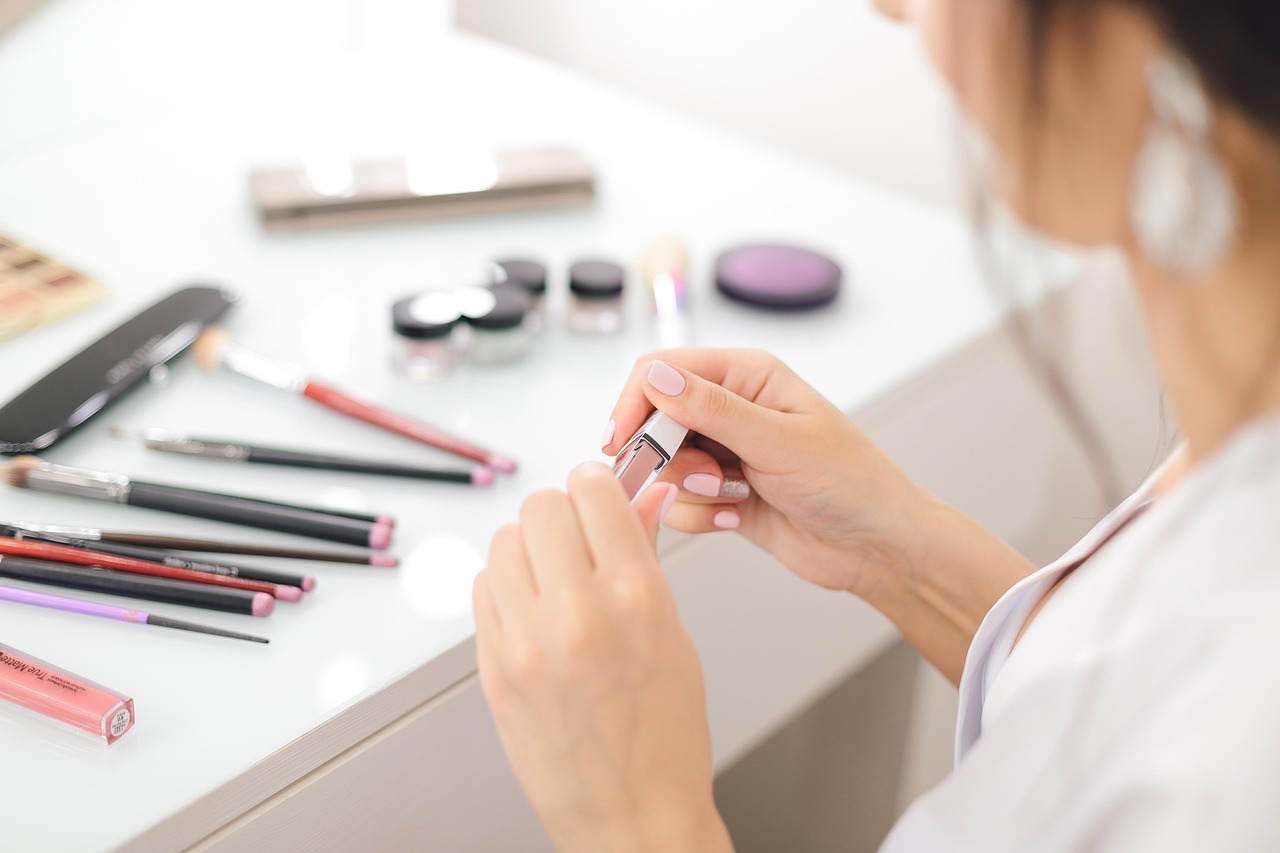 Close-up of a woman's hands applying a cosmetic product, choosing pregnancy safe skincare brands.