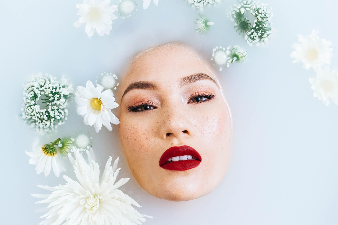 A woman relaxes in a milky bath, considering skincare brands safe for pregnancy.