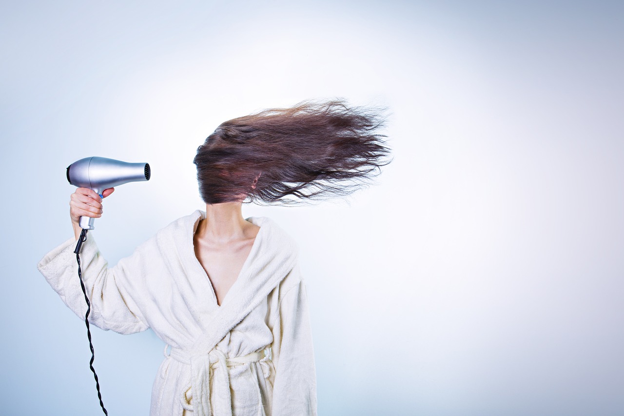 Woman blow-drying hair, girl watching, pondering pregnancy-safe choices with the Think Dirty app.