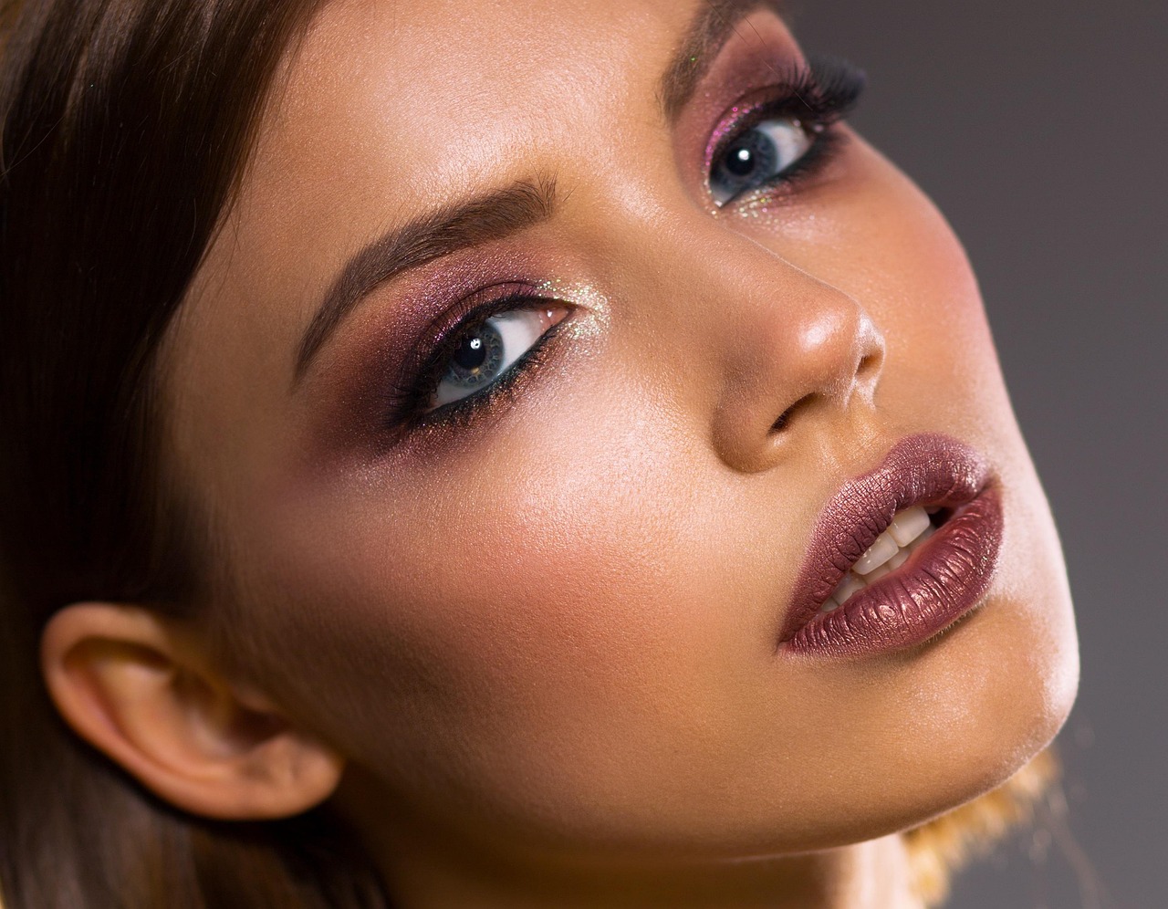 Close-up portrait of a young woman with glowing skin, considering skincare choices during pregnancy.