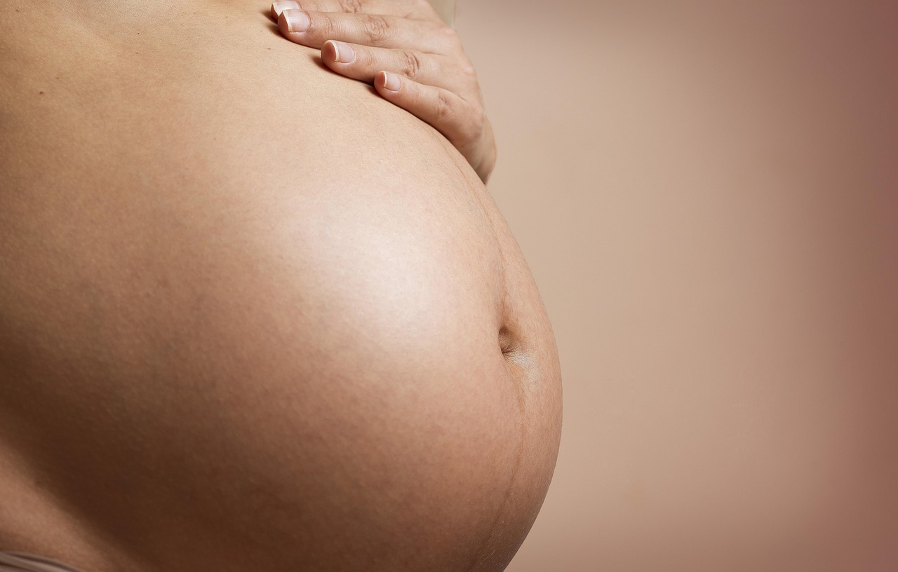 A pregnant woman's serene belly, highlighting the need for safe mineral sunscreen during gestation.