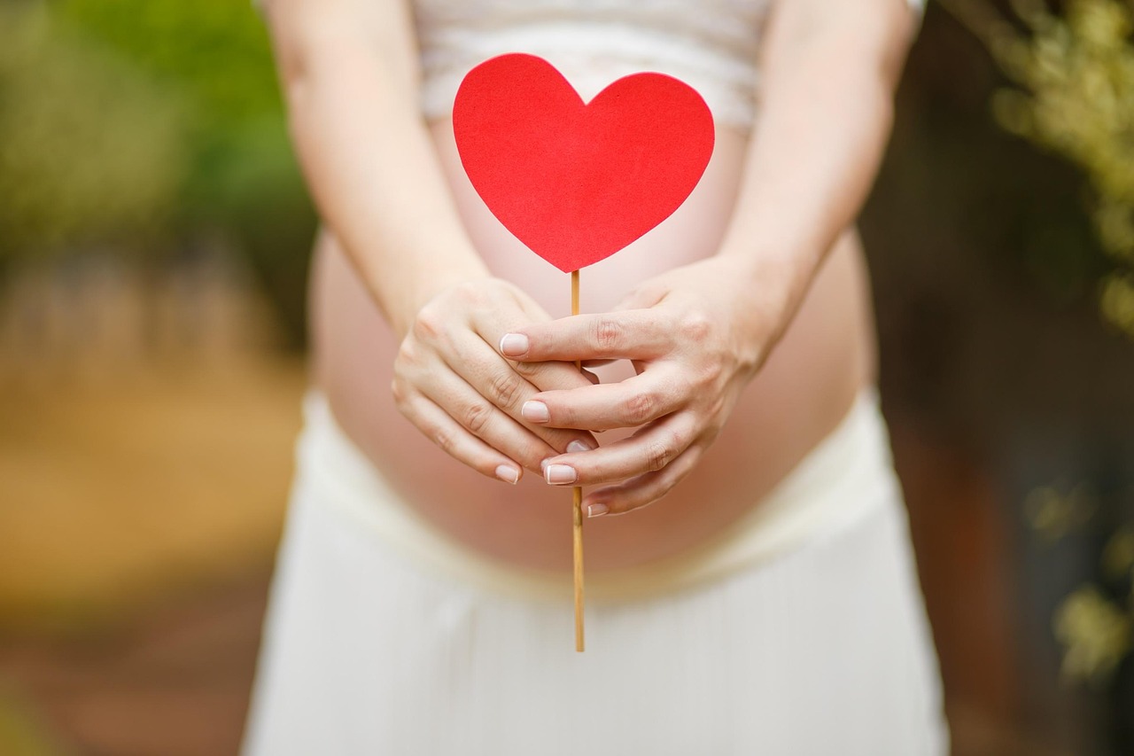 A pregnant woman cradles her prominent belly, illustrating SafeMom's August 2026 Pregnancy Ingredient Safety Index.