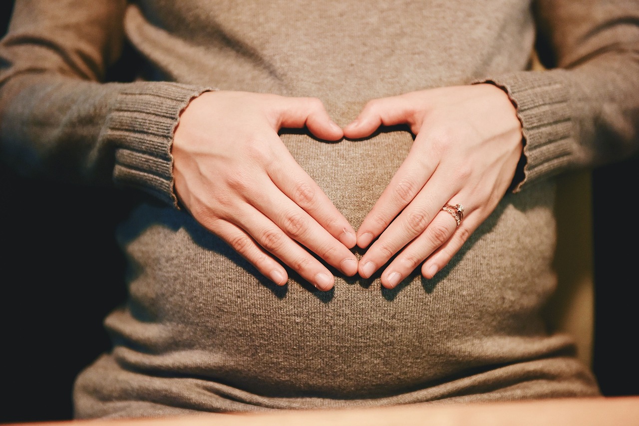 A pregnant woman thoughtfully scans a product, highlighting Yuka's role in healthy choices for new parents.