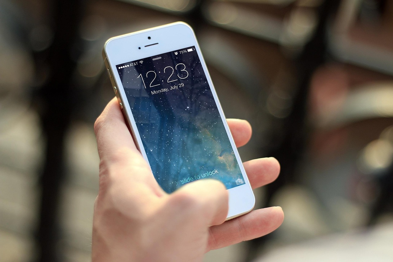 Hand holding a smartphone in front of a blurred street, representing a mobile app for pregnancy-safe product checks