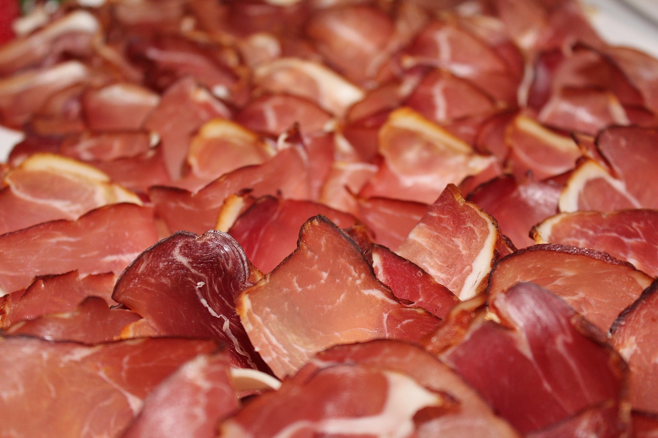 Thinly sliced smoked ham and cured cold cuts arranged in overlapping layers, representing deli meat during pregnancy
