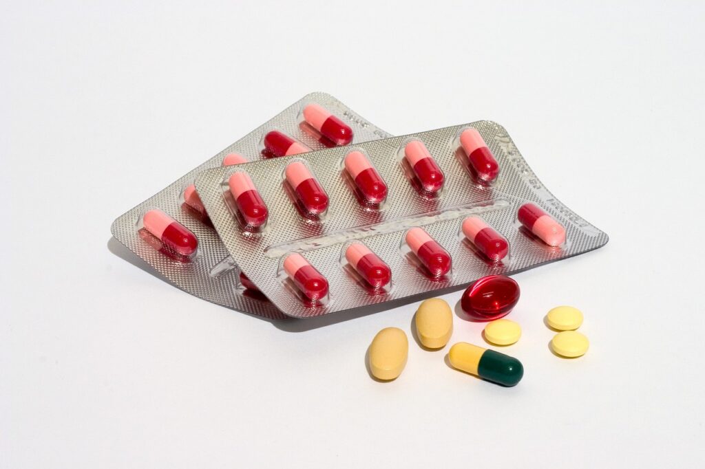 Blister packs of red capsules with loose tablets, relevant to taking cetirizine allergy medicine during pregnancy