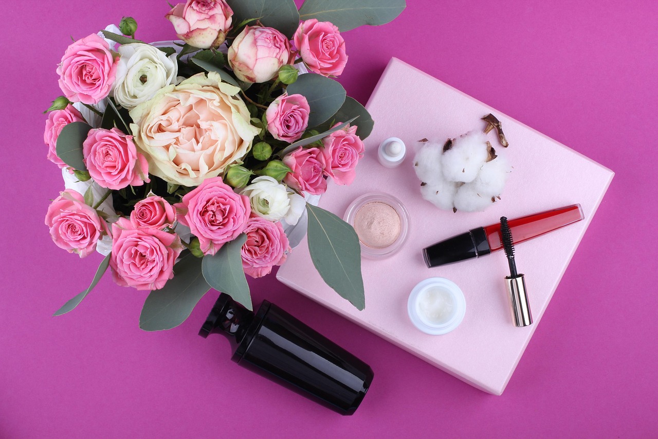 Pump bottles and small cream jars beside pink roses, representing choosing pregnancy-safe skincare products