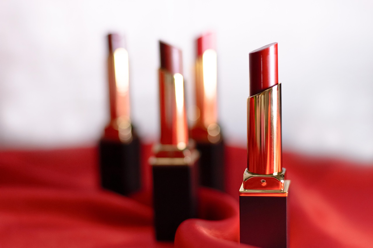 Several red lipsticks standing on red fabric, representing lipstick safety during pregnancy