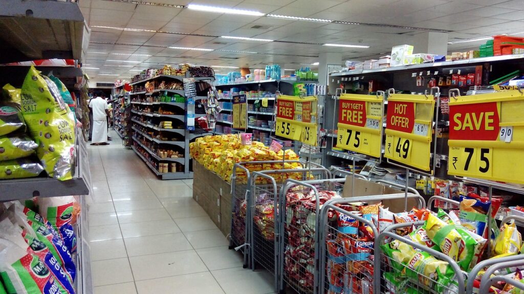 Supermarket aisle with shelves of packaged products and sale signs, representing scanning any product in seconds
