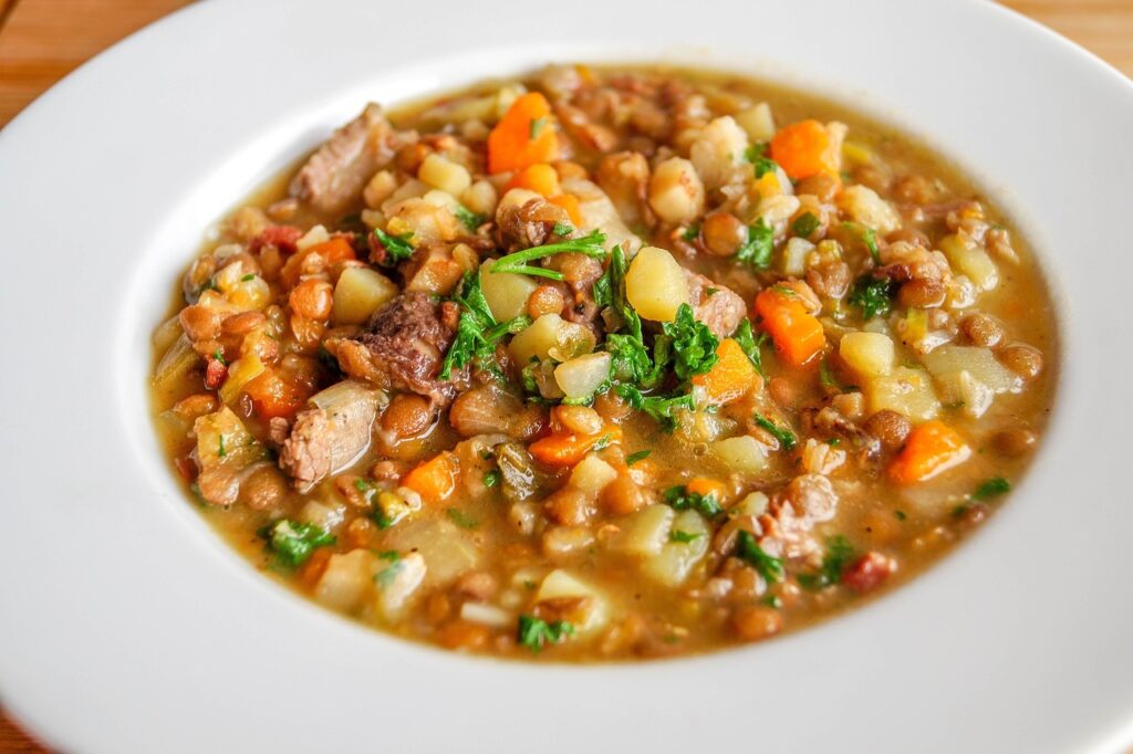 White bowl of hearty lentil and vegetable stew with carrots, an iron-rich food for pregnancy