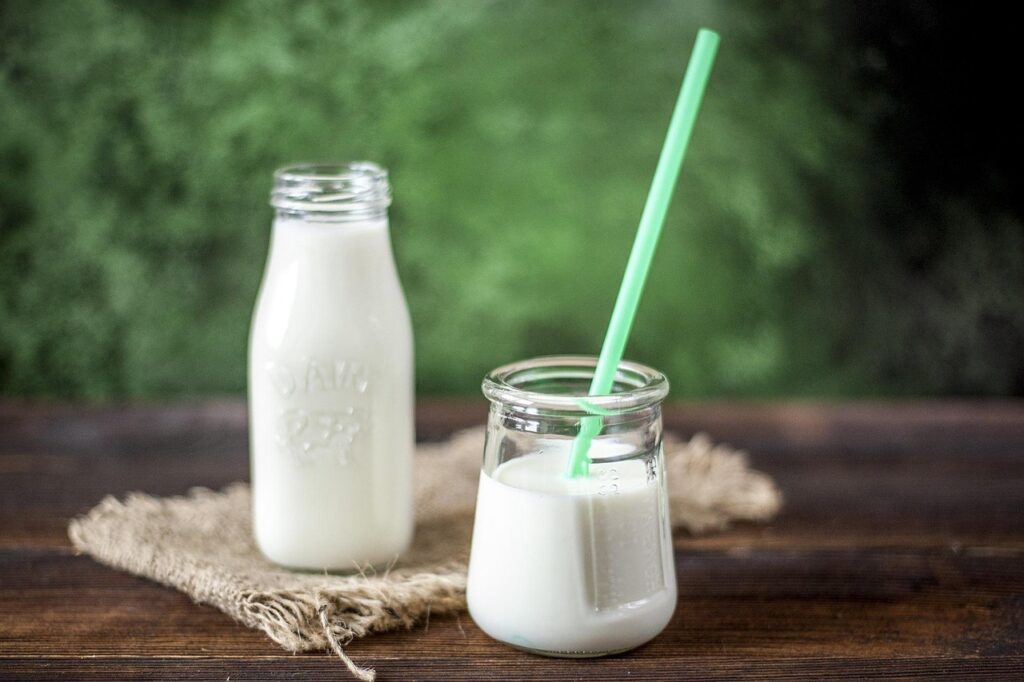 Glass bottle and jar of fresh milk with a straw, dairy foods where lactic acid occurs naturally