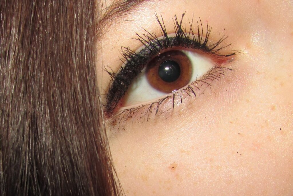 Close-up of a brown eye with long dark lashes, illustrating lash lift and tint safety during pregnancy