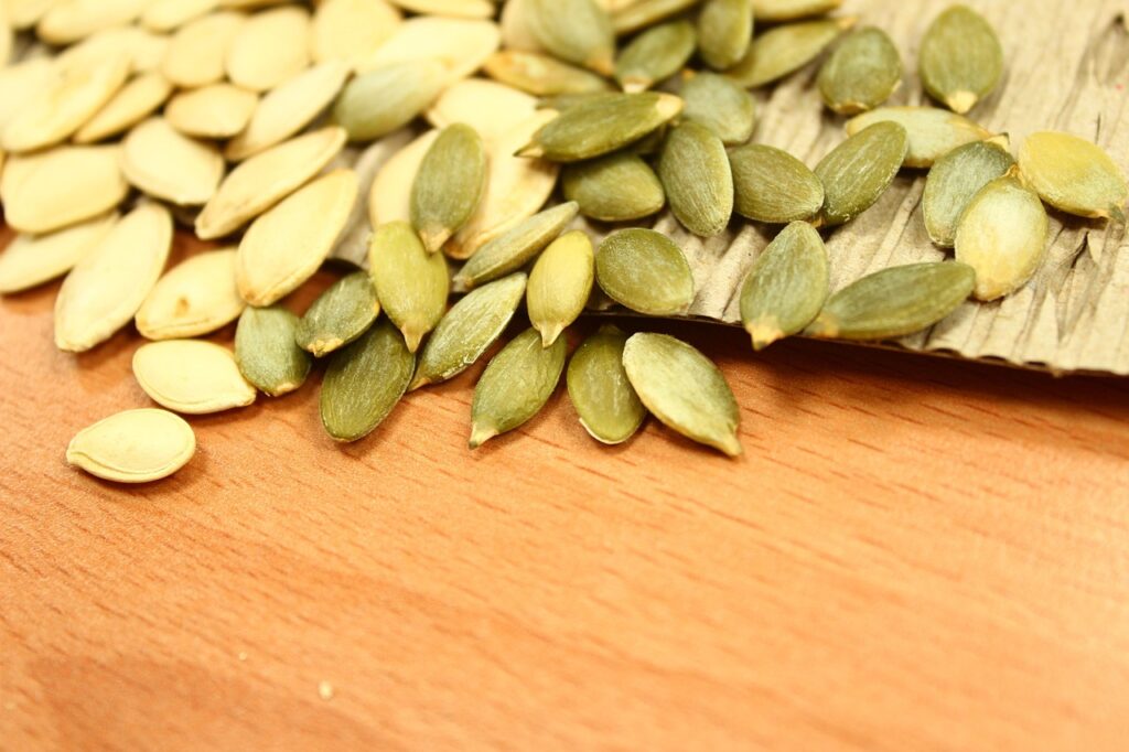 Pile of green pumpkin seeds on a wooden board, a magnesium-rich food