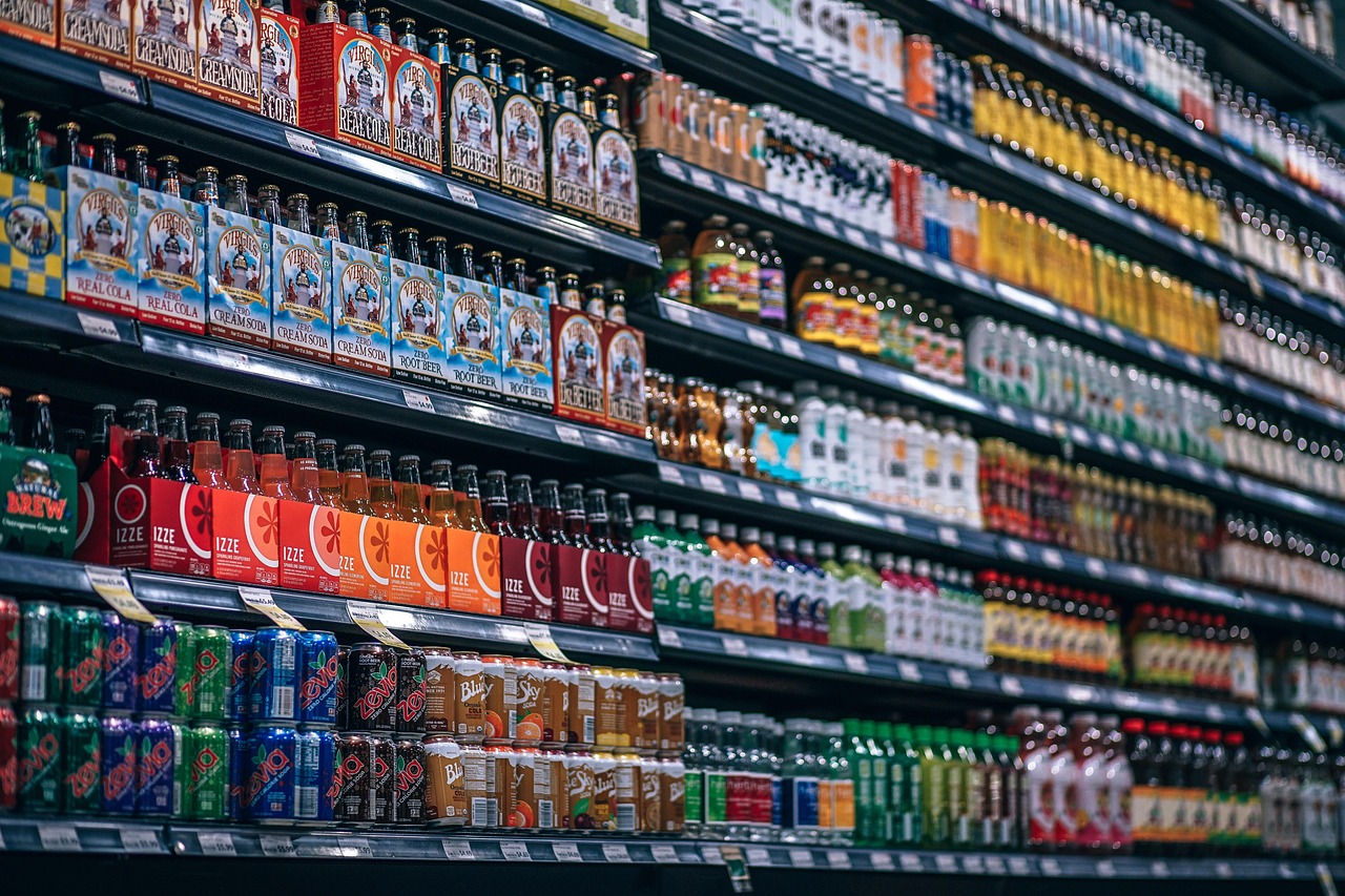 Supermarket aisle shelves stocked with packaged drinks and foods, representing scanning food products for expecting parents