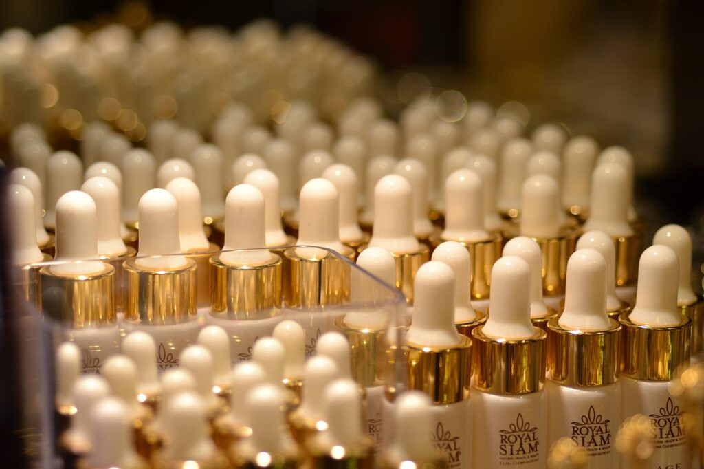 Rows of cosmetic dropper bottles with gold collars, representing niacinamide serum skincare