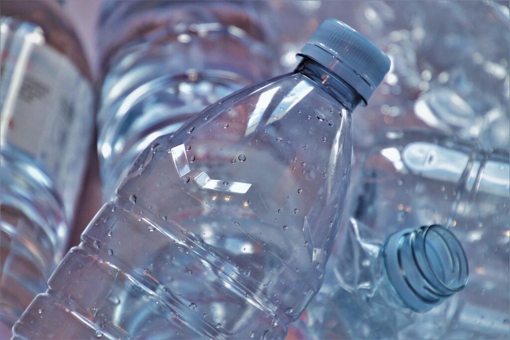 Close view of clear plastic bottles piled together, representing hidden phthalate sources in everyday plastic products