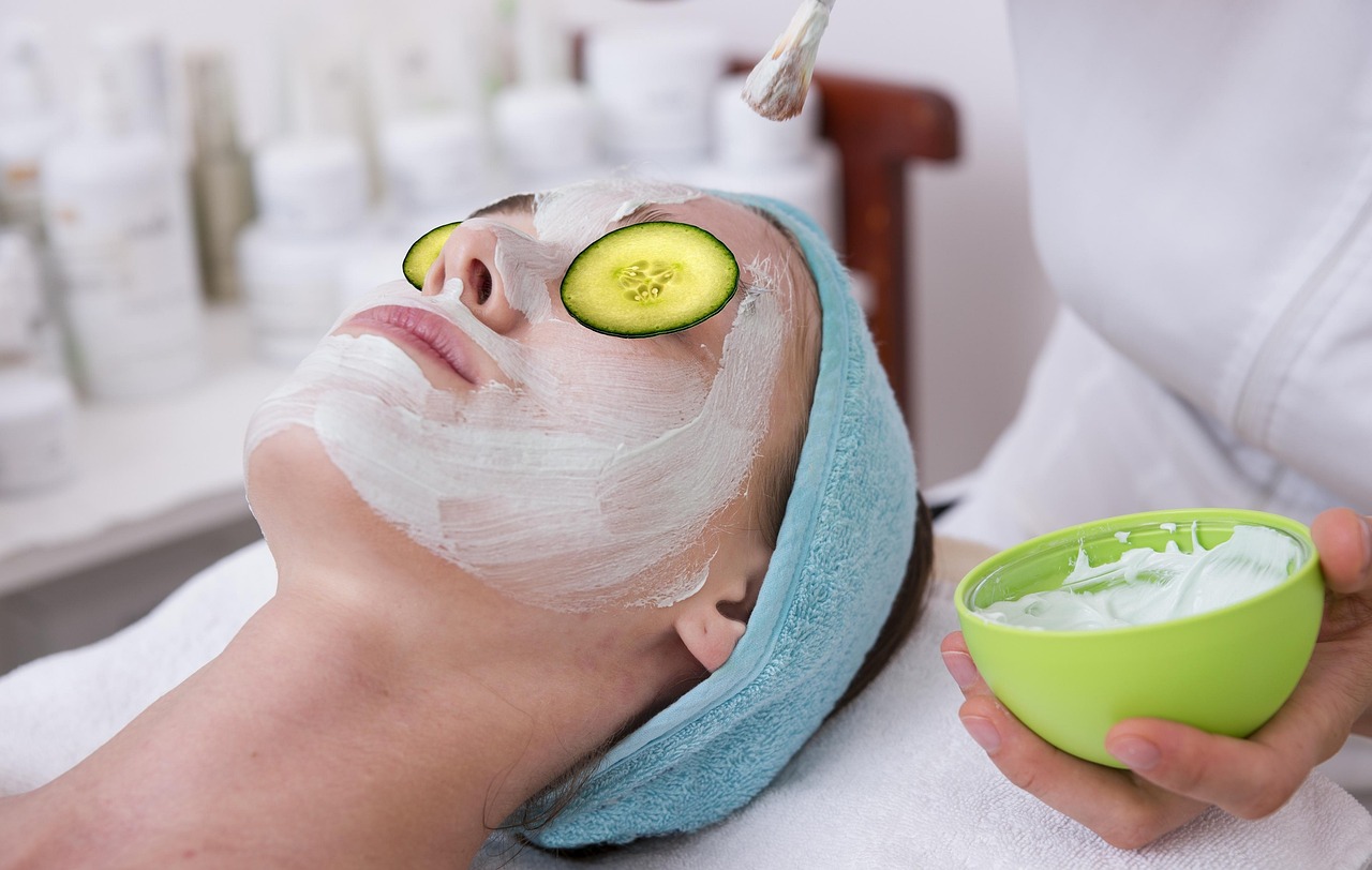 Woman resting with a cream face mask and cucumber slices, representing pregnancy glow skincare