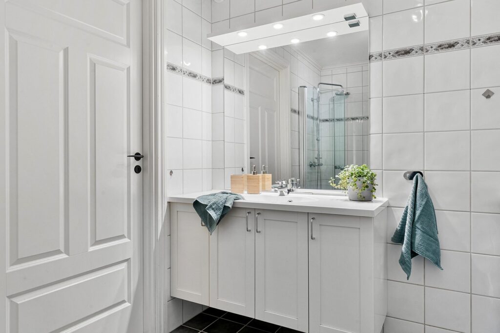 Clean white bathroom with a vanity, mirror and towel, representing a pregnancy-safe bathroom cabinet audit