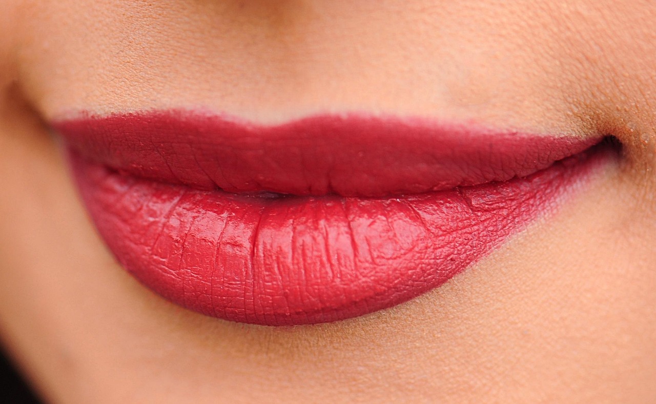 A woman's vibrant orange-red lips, a beautiful example of pregnancy safe makeup brands.
