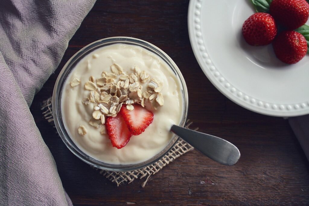 Bowl of creamy yogurt topped with strawberries and oats, a probiotic-rich food relevant to probiotics in pregnancy