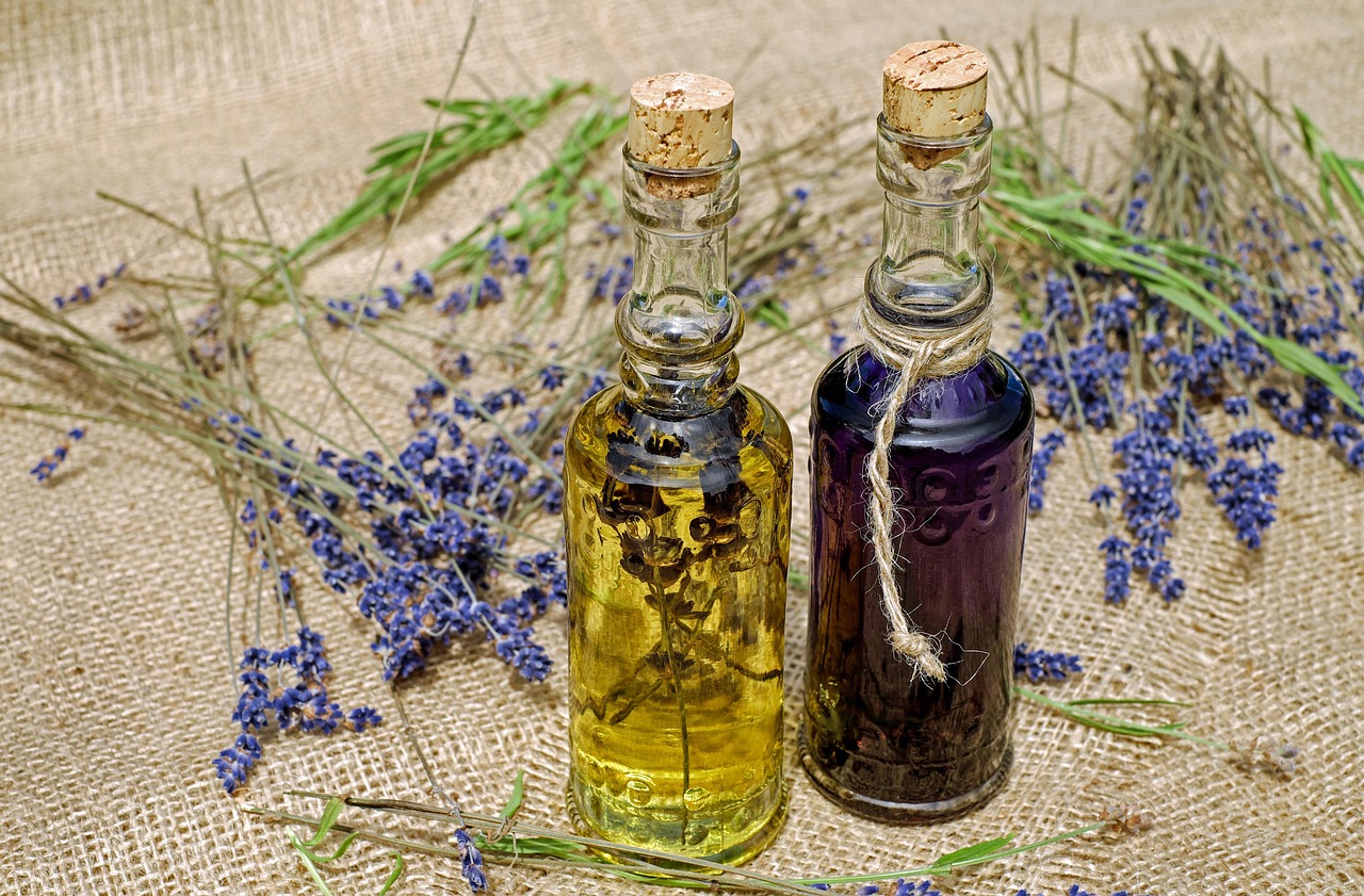 Glass bottles of lavender oil among dried lavender sprigs on burlap, representing essential oils during pregnancy