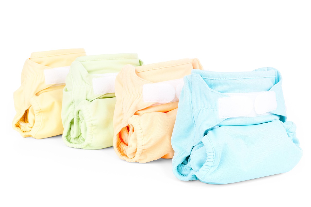 Row of colorful cloth diapers in pastel yellow, green, orange and blue, representing baby products to scan before use