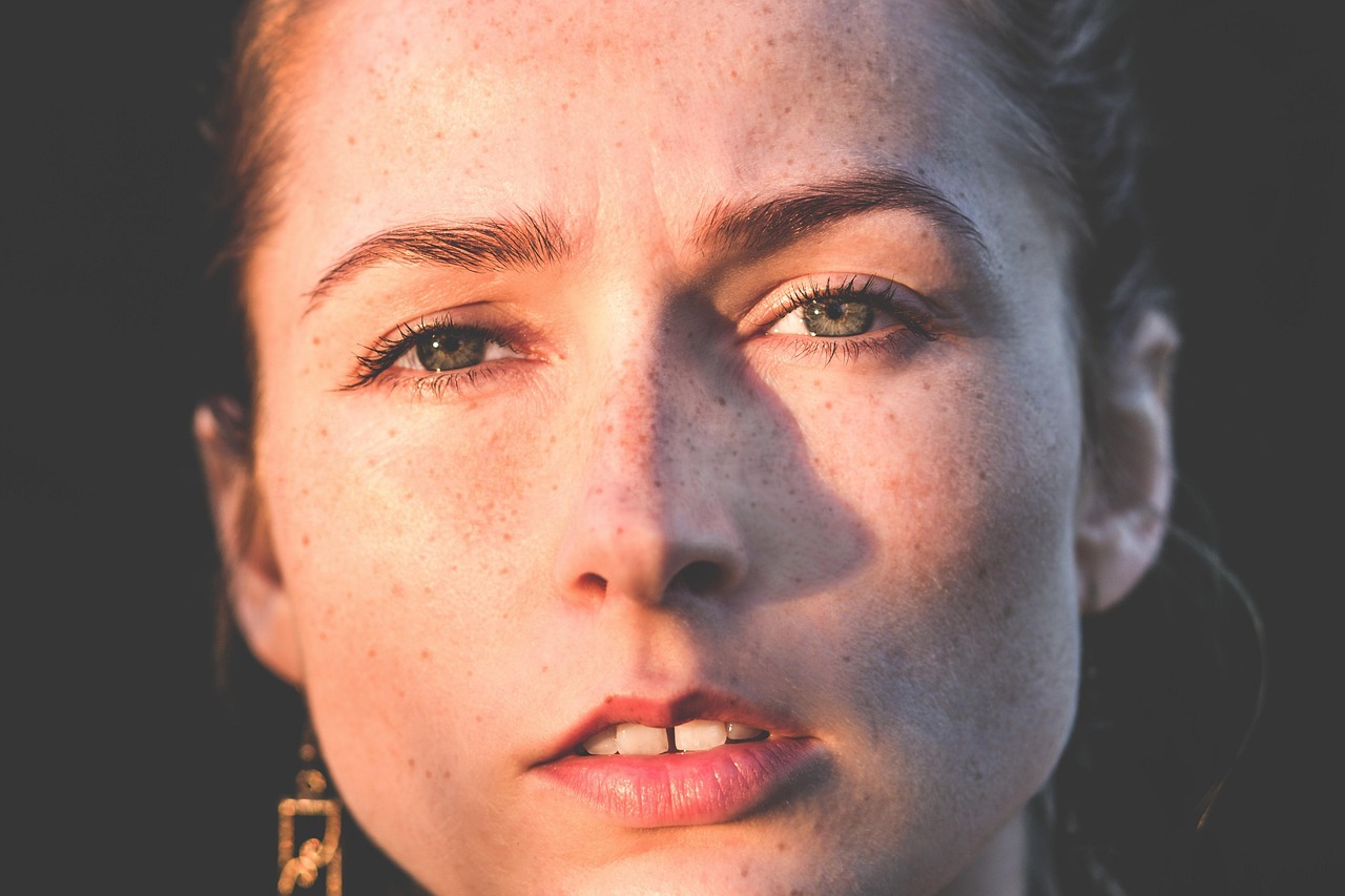 Young woman's clear, freckled skin, pondering The Ordinary Azelaic Acid Suspension 10% for pregnancy safety.