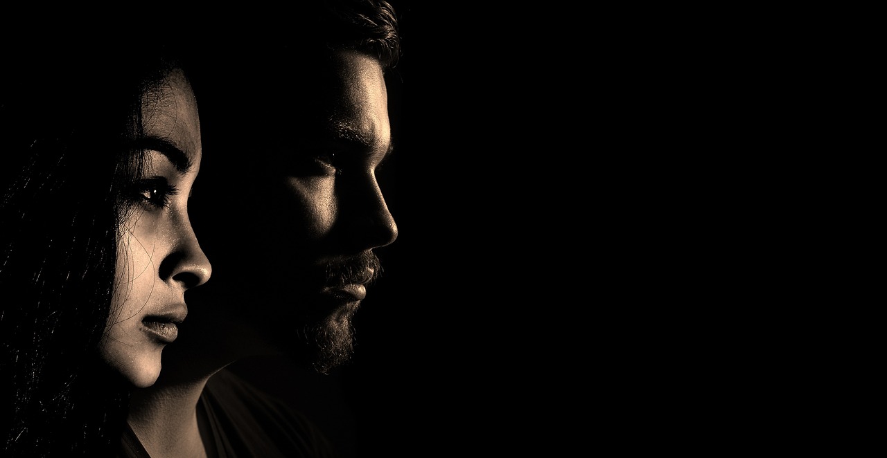 A thoughtful man and woman in silhouette, considering the safety of glycolic acid during pregnancy.