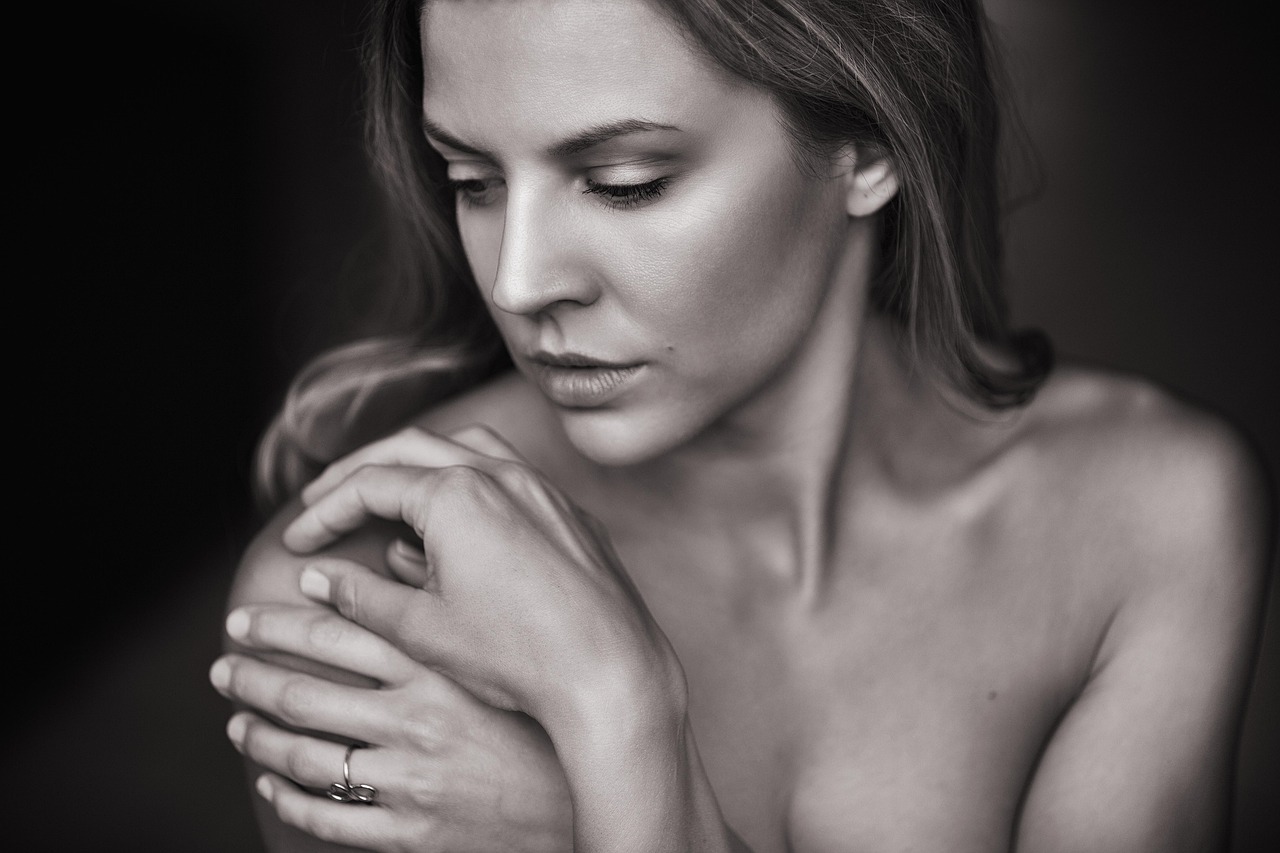 Portrait of a woman with clear skin, hands gently touching her face, pondering if Cleocin T is safe during pregnancy.
