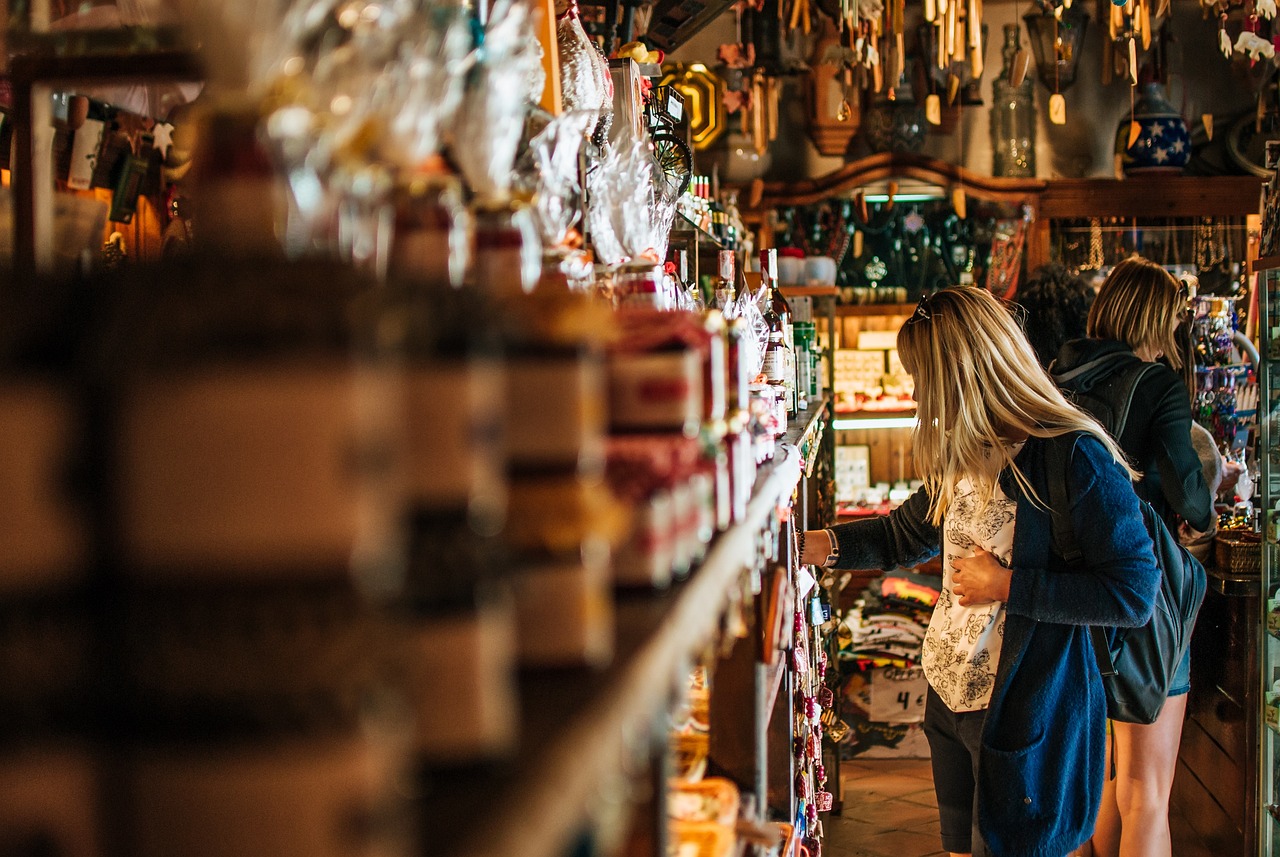 A woman thoughtfully examining products on shop shelves, navigating safe skincare choices like mandelic acid during pregnancy