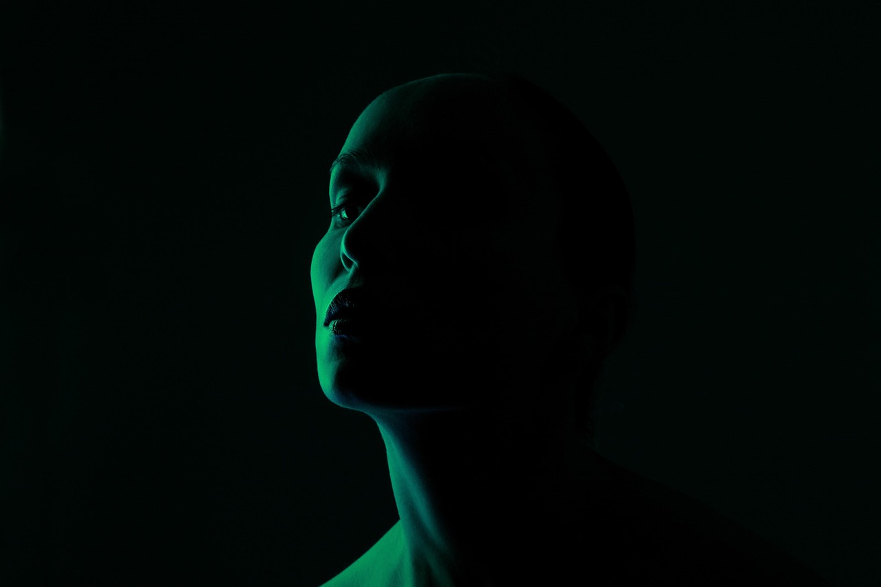 Woman's face in dramatic green light, for Paula's Choice 2% BHA Liquid Exfoliant safety during pregnancy.