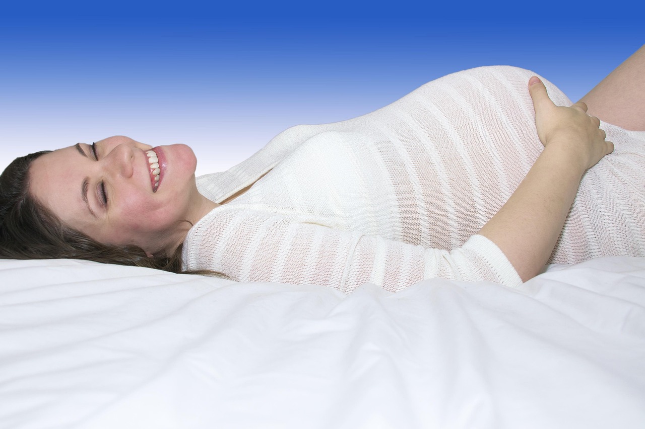 Smiling young pregnant woman in a striped top, her belly visible, wondering if Herbivore Botanicals Bakuchiol is safe during