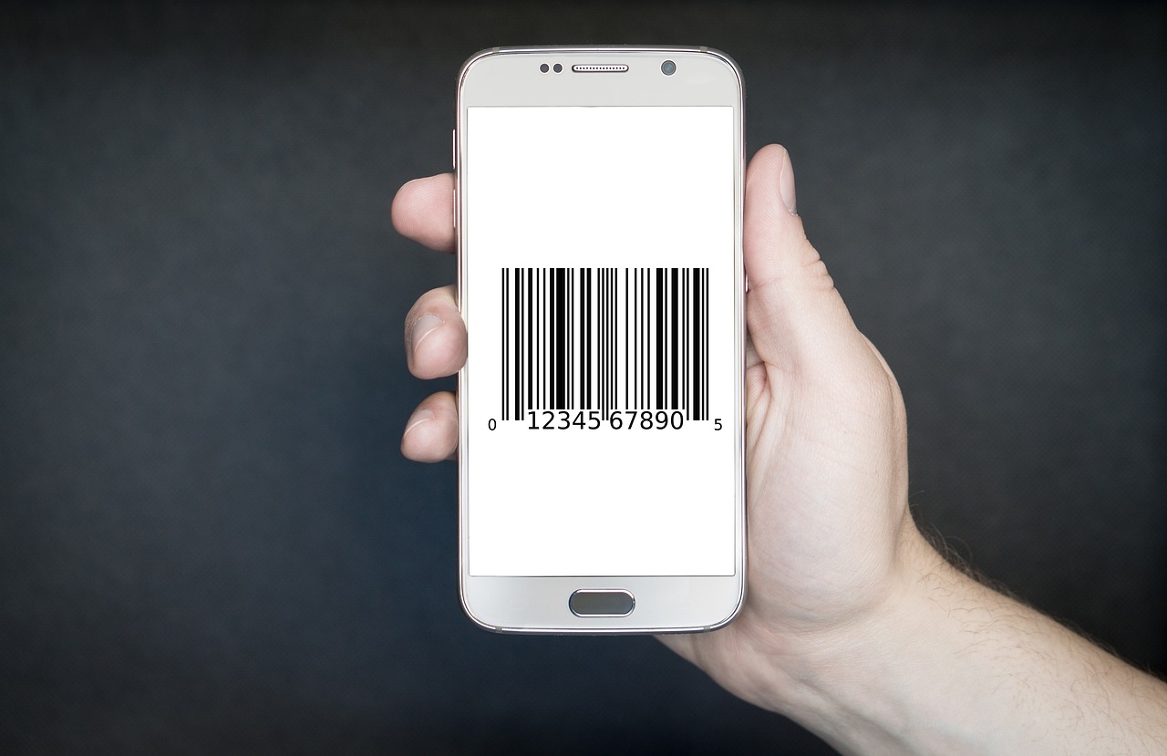 Hand holding a smartphone displaying a barcode, representing product scanning and ingredient lookup accuracy