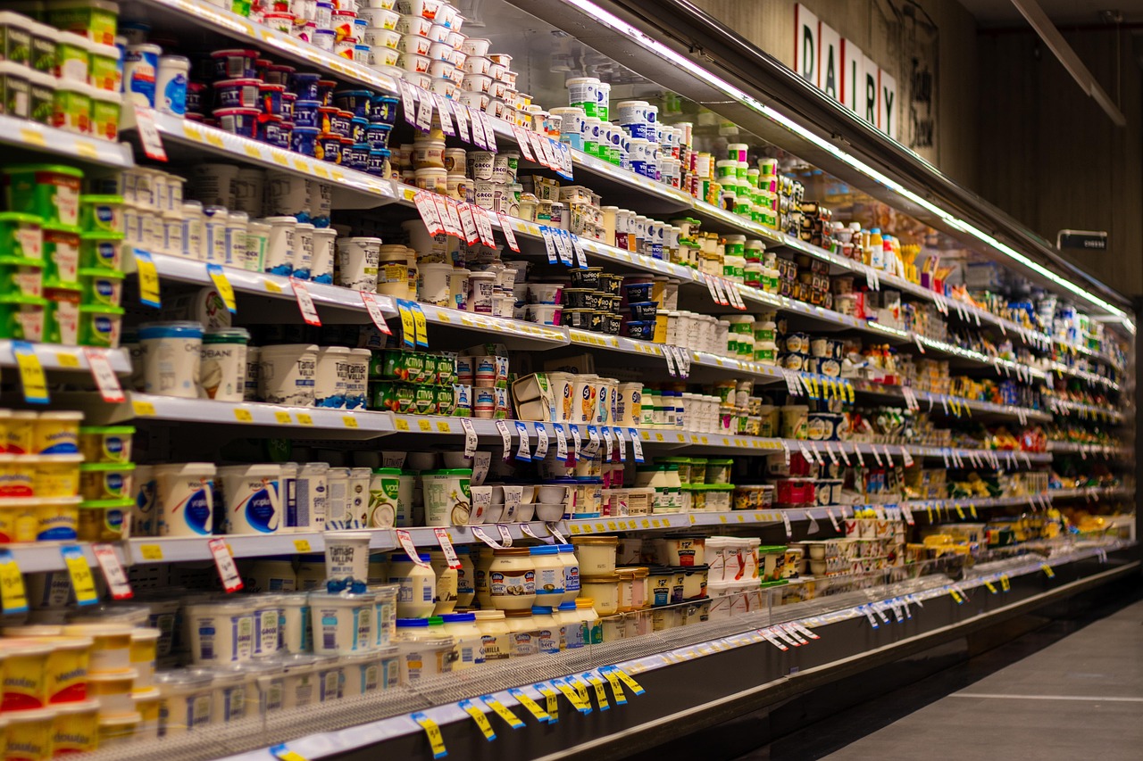 Supermarket aisle shelves stocked with dairy and packaged groceries, representing smarter shopping with a pregnancy safe checker