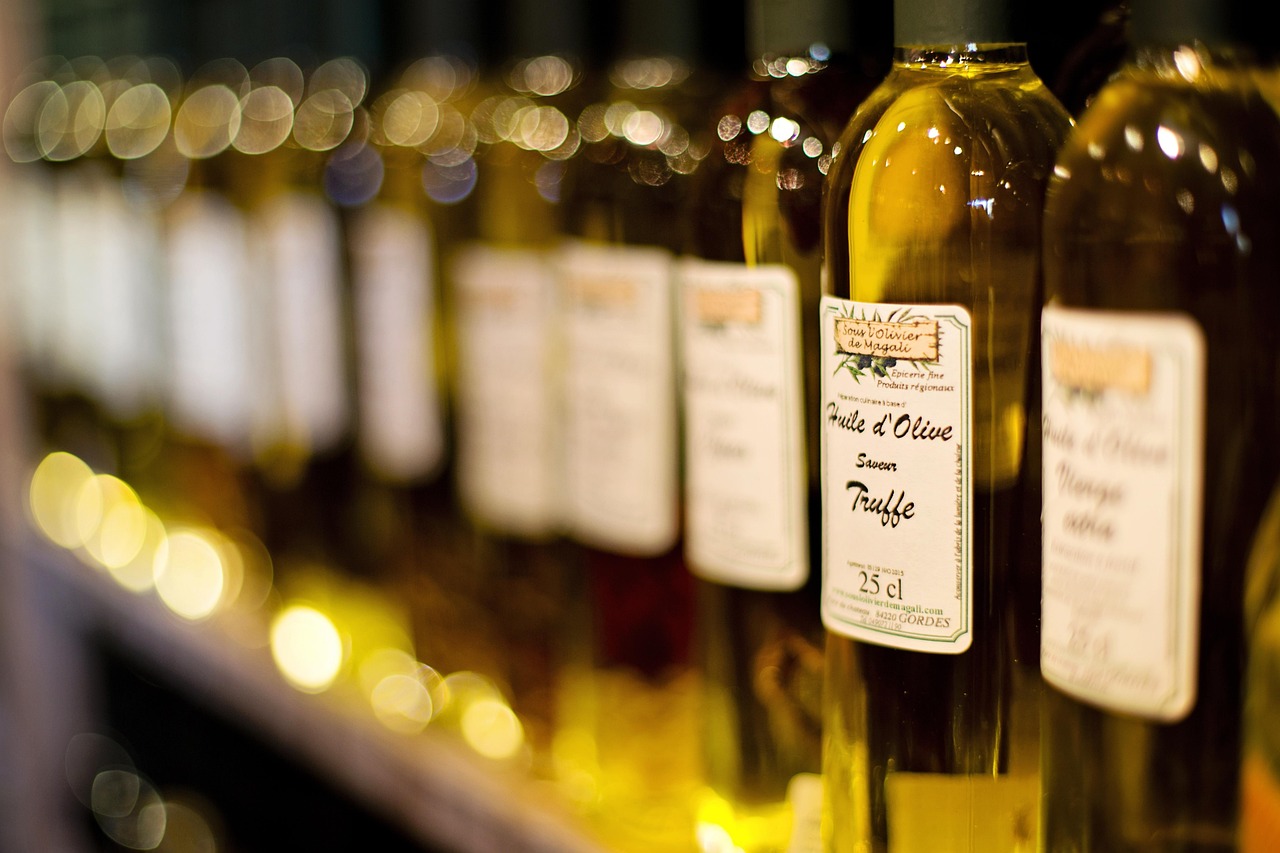 Row of glass bottles of olive oil with printed labels on a shelf, representing reading ingredient labels