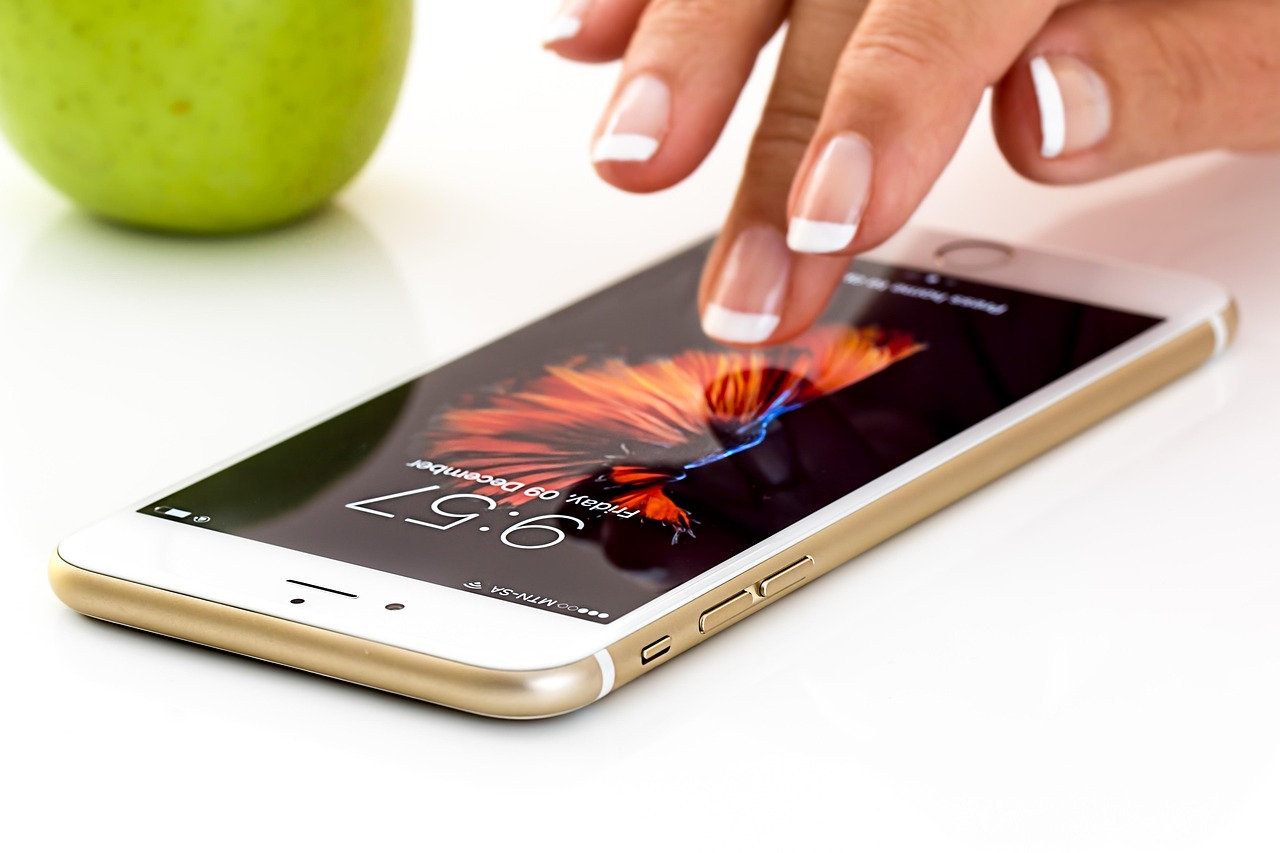 Hand holding a smartphone with app icons on the screen, representing pregnancy and mom apps