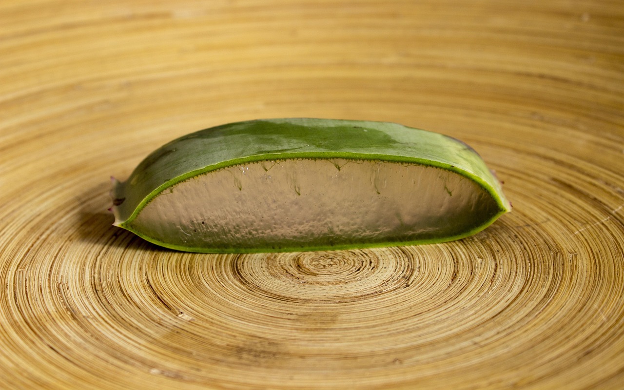 Sliced aloe vera leaf on a round wooden board, representing gentle natural skincare during pregnancy
