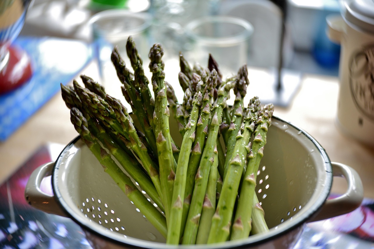 Fresh green asparagus in a kitchen, representing food choices and the safety breakdown of unpasteurized dairy during pregnanc