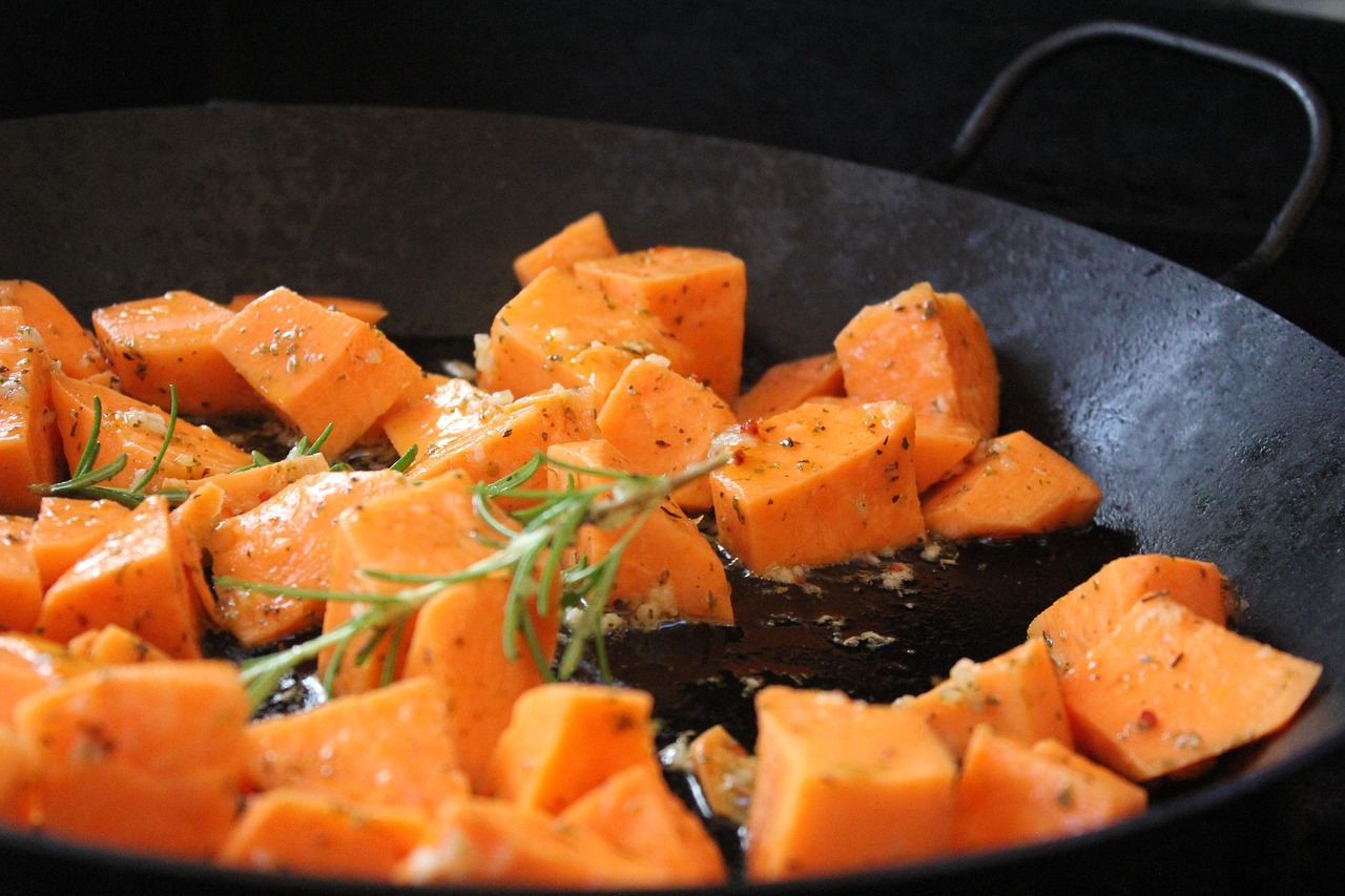 Sweet potato slices grilling in a pan, a nutritious choice for sweet potato during pregnancy safety.