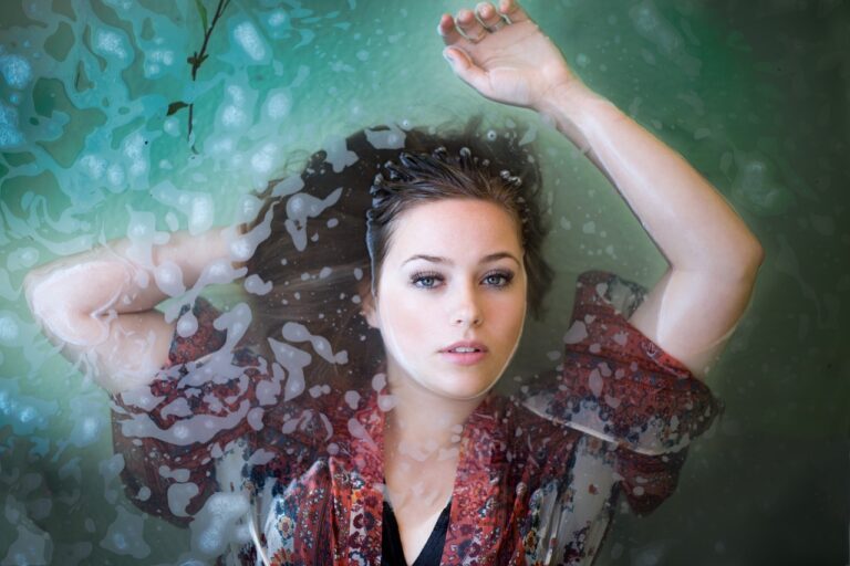 Wet portrait of a young woman floating in water, embodying the gentle safety of colloidal oatmeal for pregnancy.