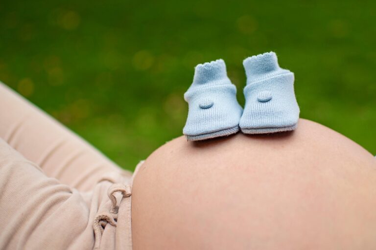 Pregnant belly with tiny baby shoes, representing the full safety breakdown of glycerin during pregnancy moms ask about.
