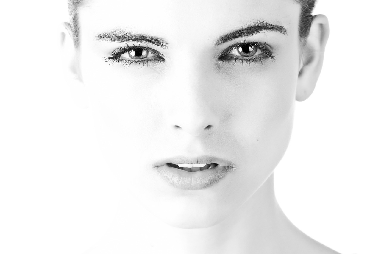 Monochrome portrait of a young woman with glowing skin, exploring polyglutamic acid safety for pregnancy skincare.