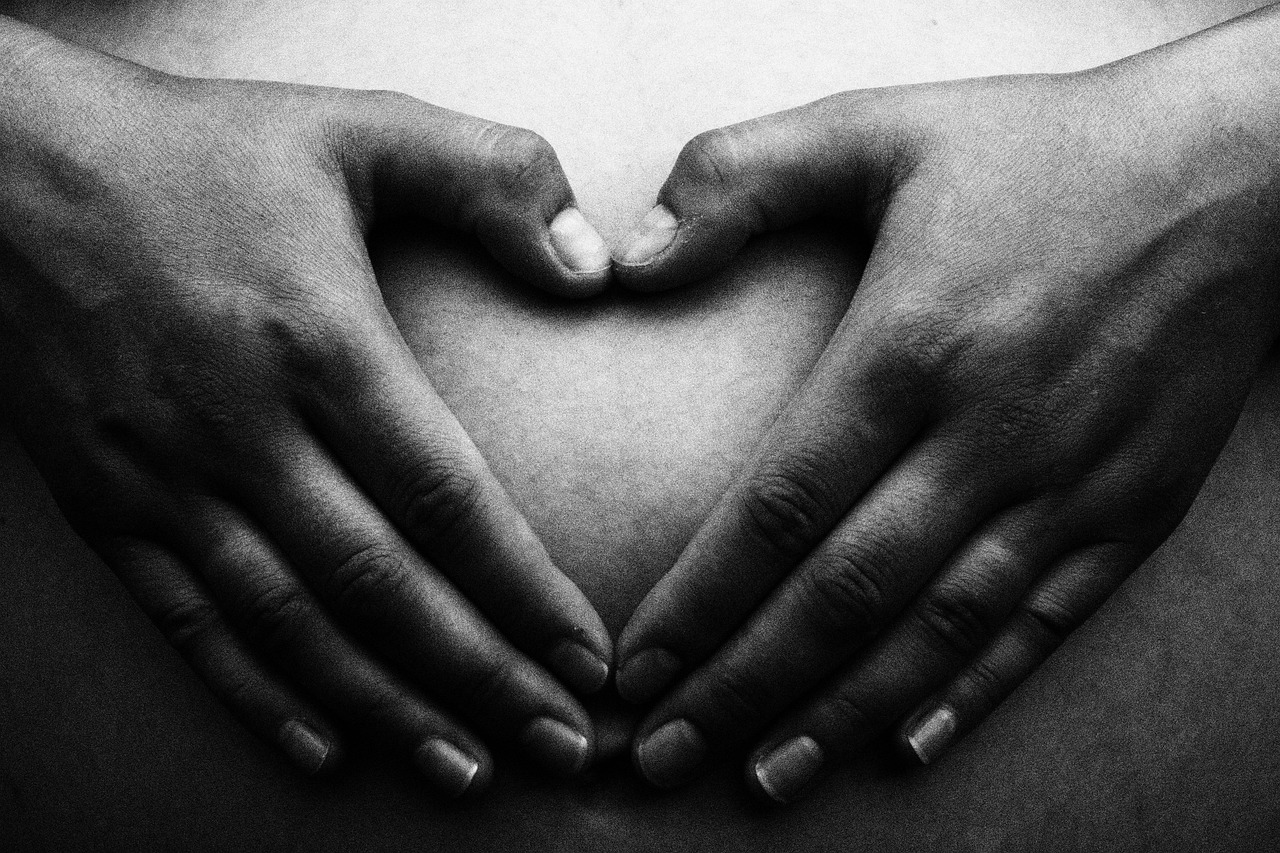 A pregnant belly with a heart, illustrating the safety considerations of shea butter for expectant mothers.