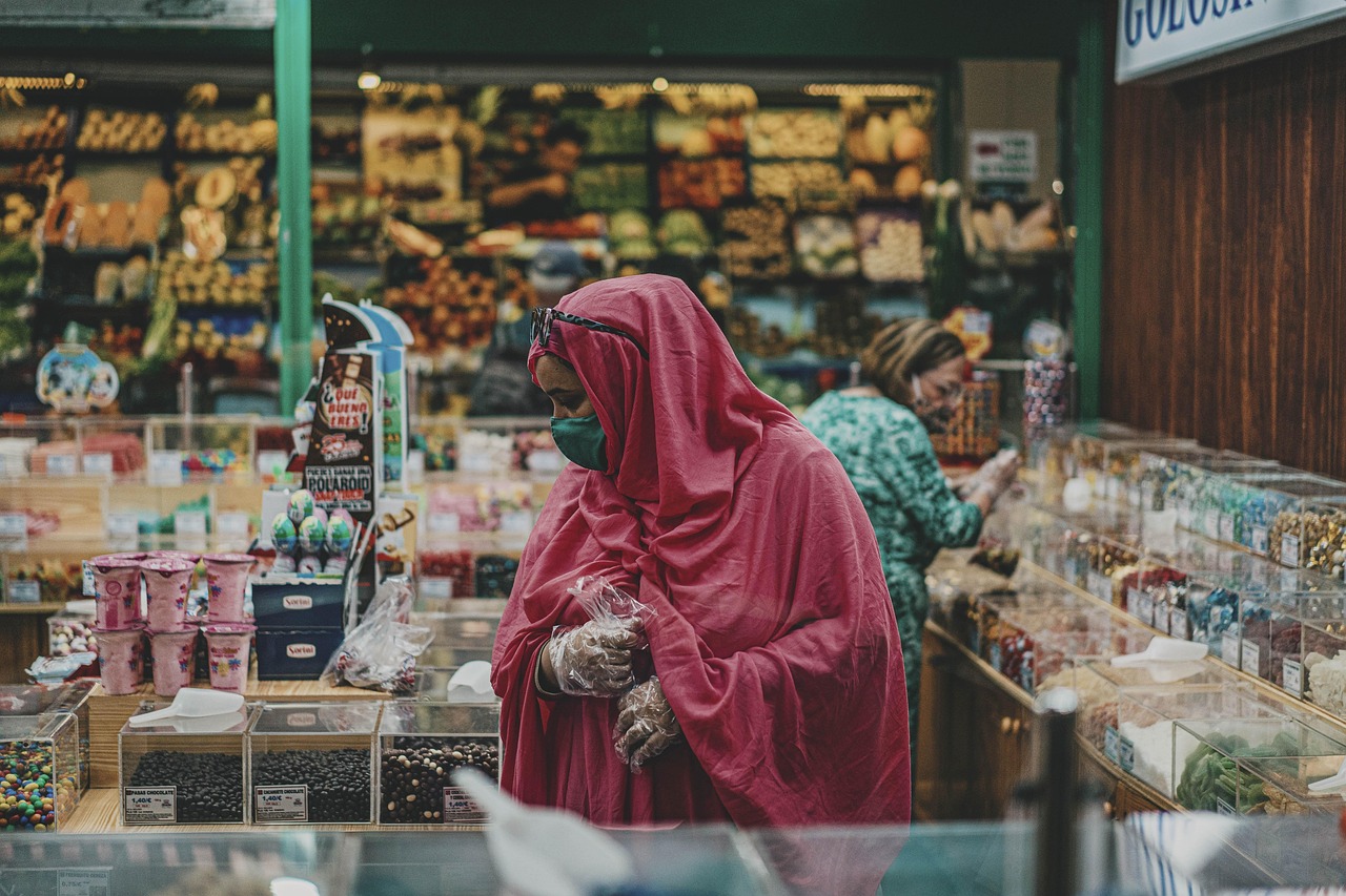 Woman in hijab and mask shops at a market, mindful of high-mercury fish choices for pregnancy.