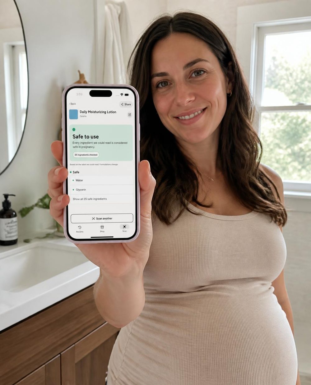 A pregnant woman holding a phone that shows a Safe to use result